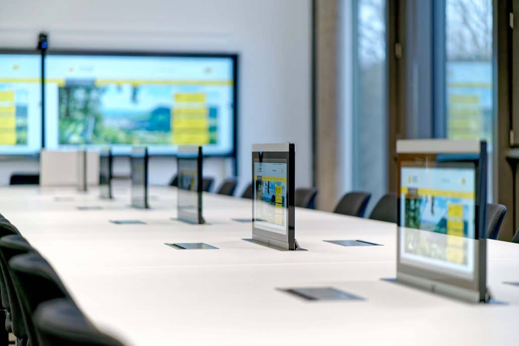 Ausfahrbare Mitschaudisplays in Meetingraum des Landratsamts Esslingen für digitale Gremienarbeit und hybride Meetings.